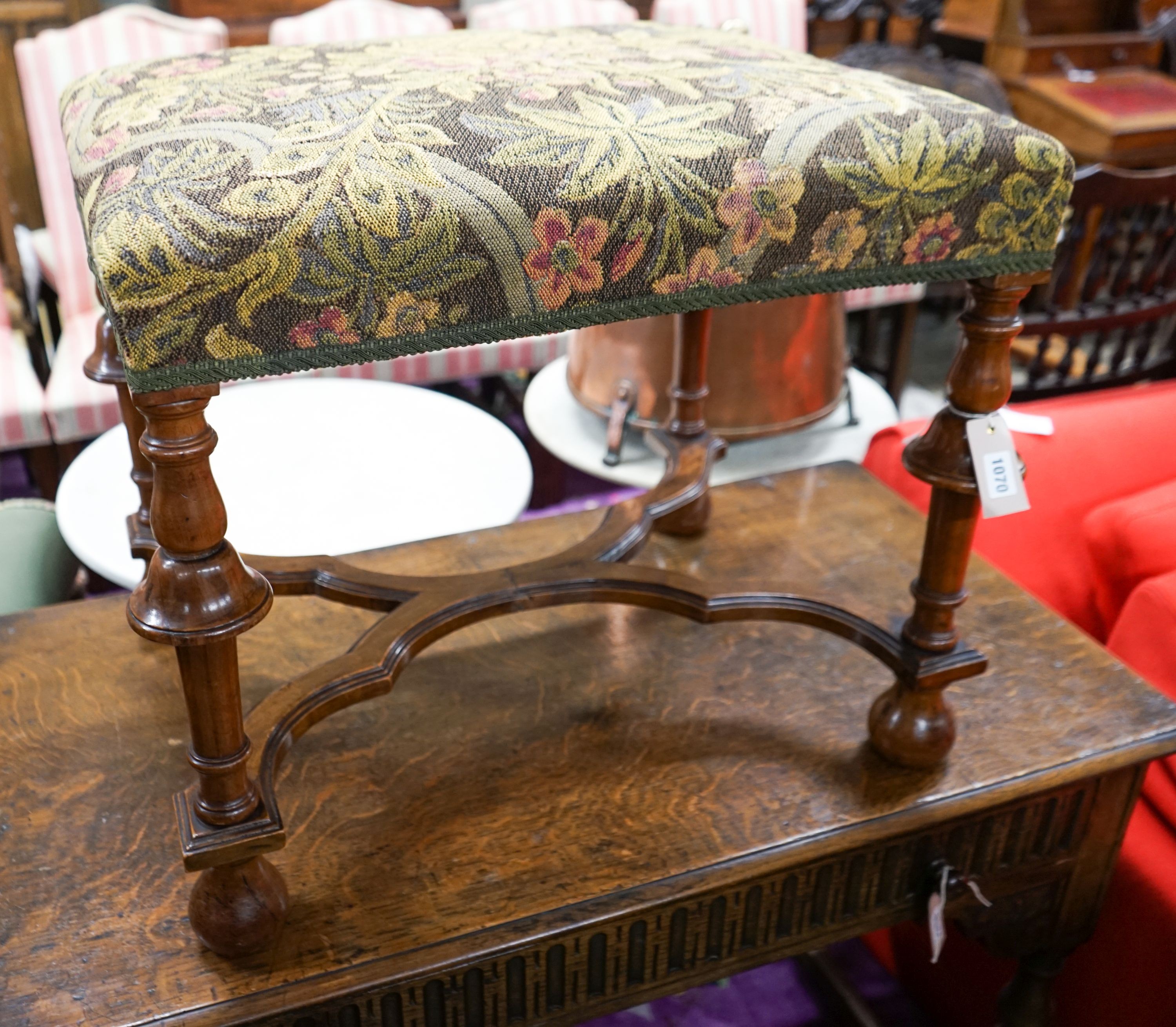 A William and Mary style walnut stool, having embroidery-covered seat on turned supports with cross stretcher and ball feet, length 63cm, depth 49cm, height 54cm